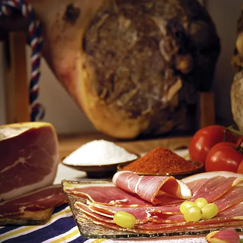 Gesneden rauwe ham met een hele ham op de achtergrond in Frans-Baskenland.