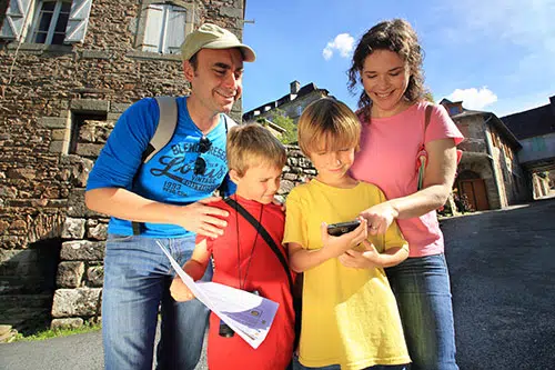 Een gezin kijkt naar een telefoon tijdens Geocoaching in Frankrijk.