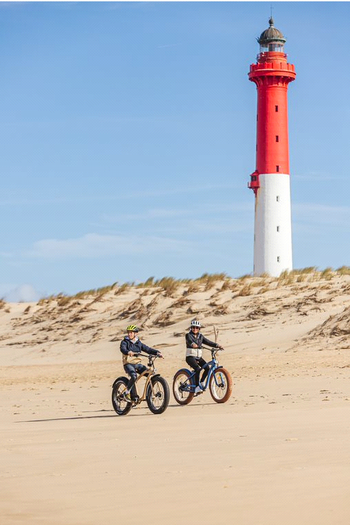 Twee mensen fietsen met fatbikes over het strand in Frankrijk.